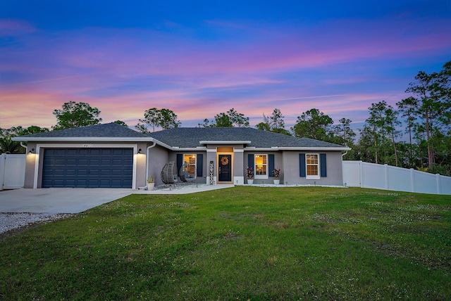 ranch-style home with a garage and a lawn