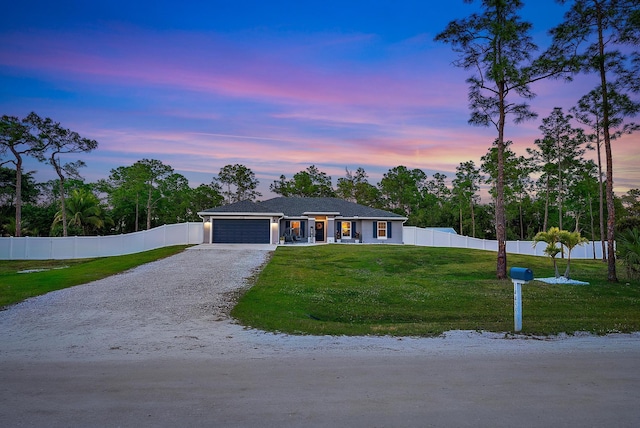 view of front of house with a garage and a lawn