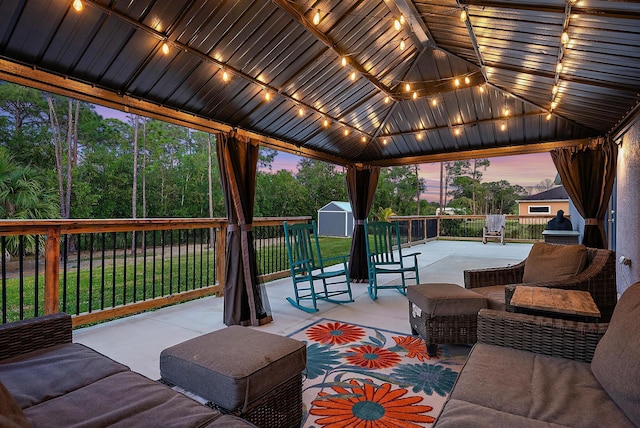 patio terrace at dusk with a storage shed and a gazebo