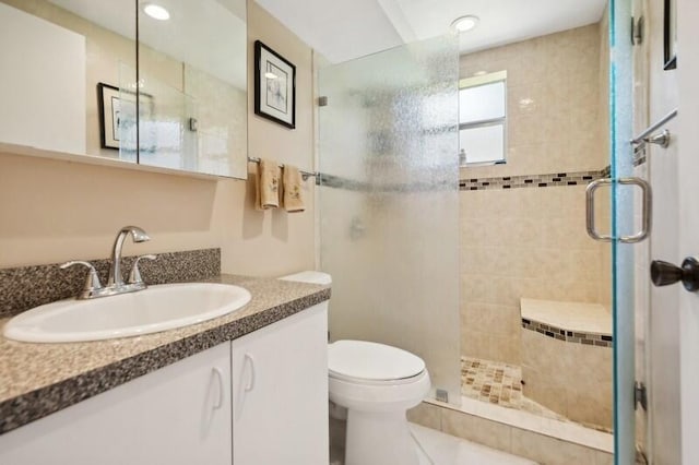 bathroom with vanity, toilet, and a shower with shower door