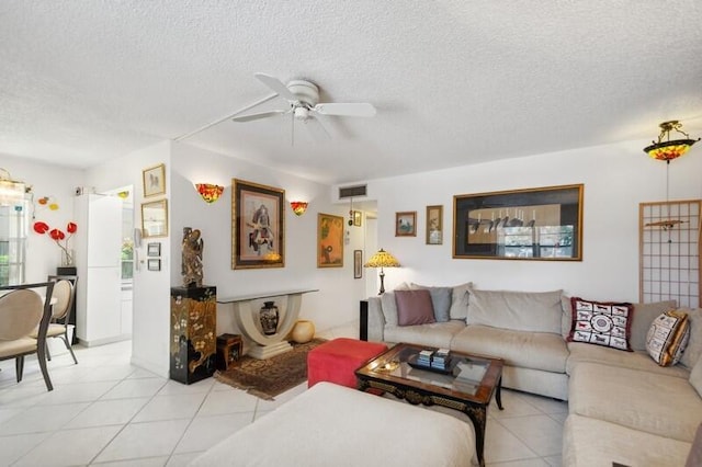 tiled living room with ceiling fan and a textured ceiling