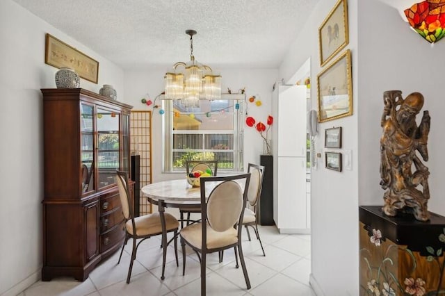 dining area featuring an inviting chandelier, a textured ceiling, and light tile patterned floors