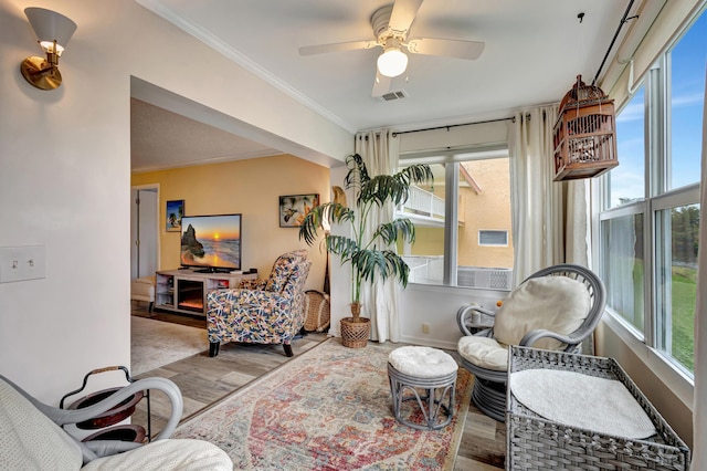 living room featuring plenty of natural light, wood finished floors, and ornamental molding