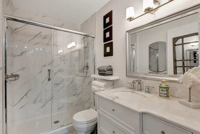 full bathroom featuring a marble finish shower, toilet, and vanity