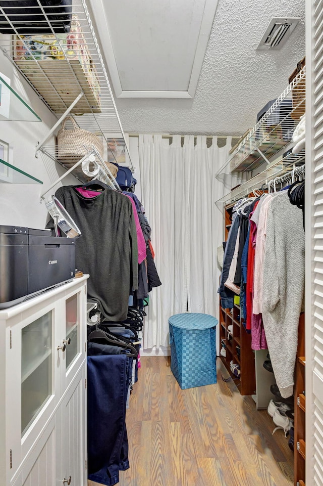 spacious closet featuring visible vents and wood finished floors