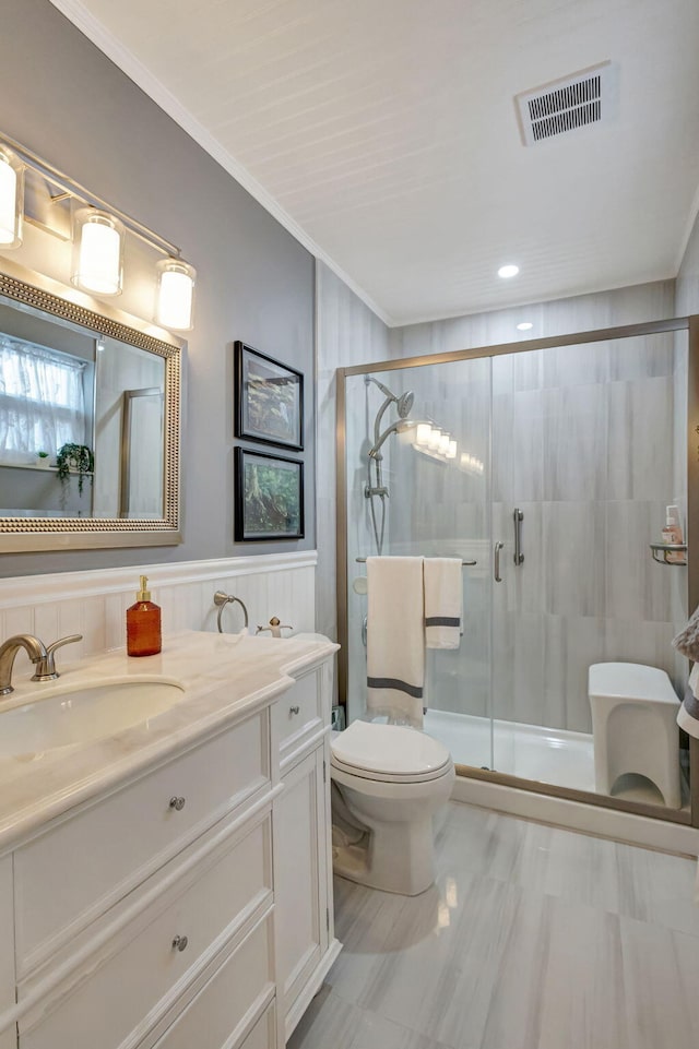 bathroom with vanity, visible vents, a stall shower, ornamental molding, and toilet