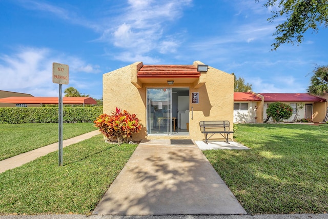 exterior space with a lawn and stucco siding