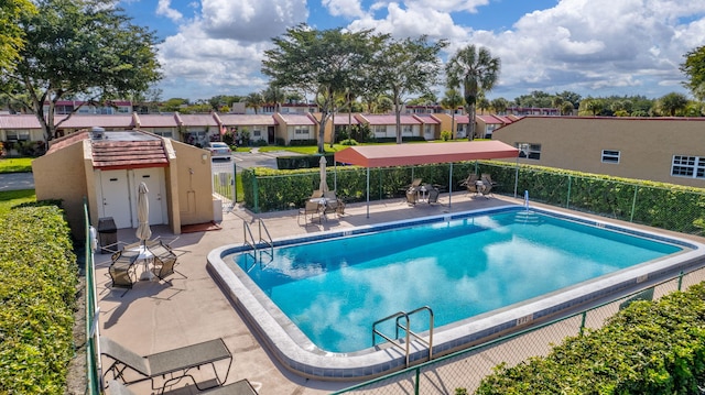 view of pool featuring a residential view and fence