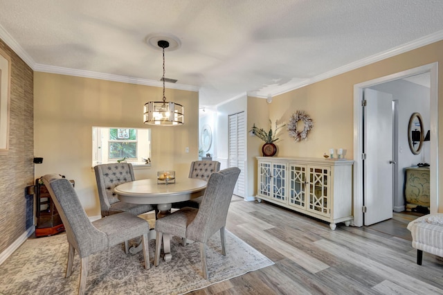 dining area featuring a textured ceiling, wood finished floors, and ornamental molding