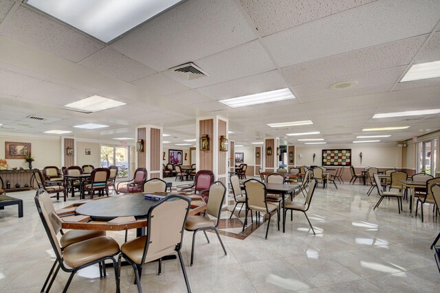 dining area with light tile patterned floors, visible vents, and a paneled ceiling