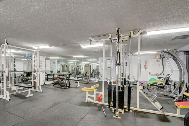 exercise room featuring visible vents and a textured ceiling