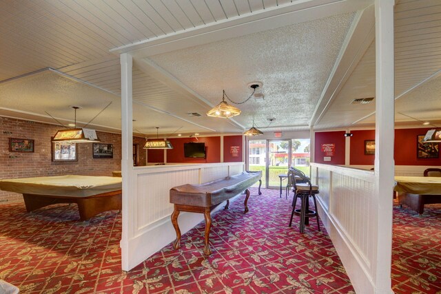 playroom featuring billiards, carpet, brick wall, and a textured ceiling