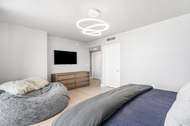 bedroom with a notable chandelier and light hardwood / wood-style floors