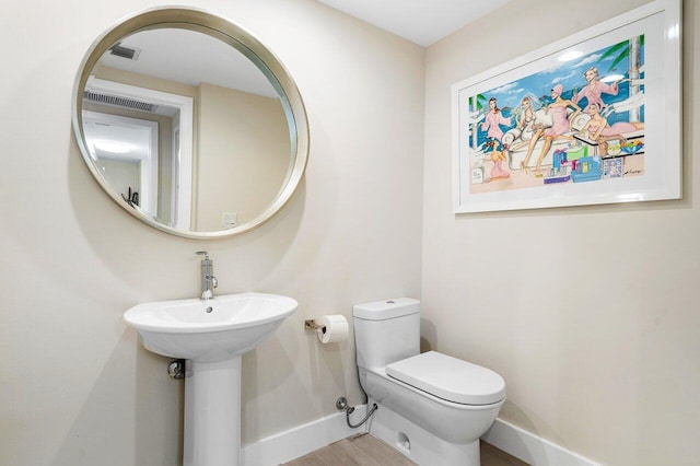 bathroom with sink, hardwood / wood-style flooring, and toilet