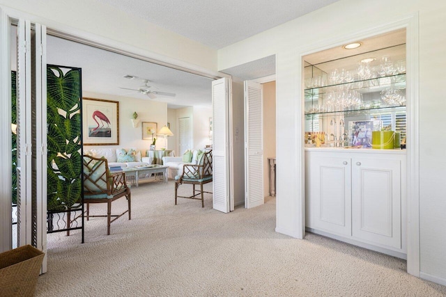 bar with light colored carpet and ceiling fan