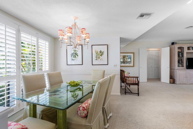 dining area featuring light colored carpet, a textured ceiling, and an inviting chandelier