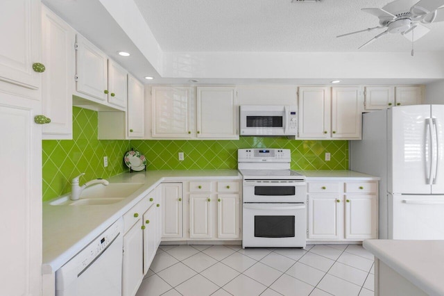 kitchen featuring white cabinetry, sink, white appliances, and light tile patterned floors