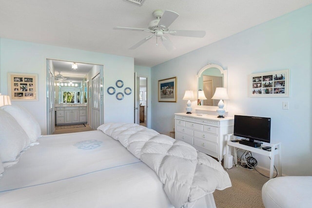 carpeted bedroom with ensuite bathroom and ceiling fan