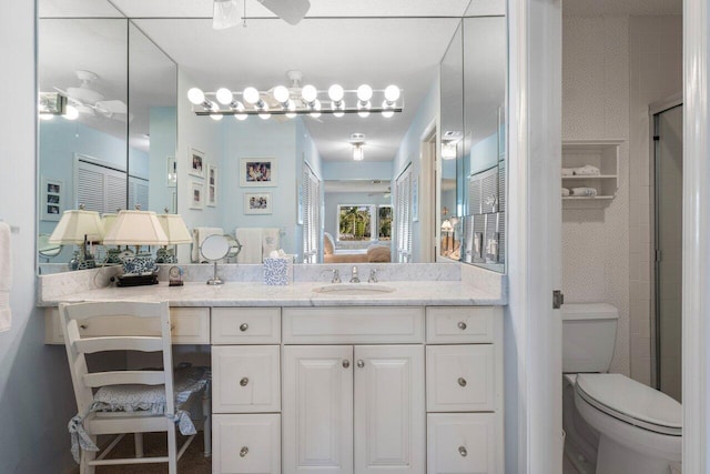 bathroom with vanity, ceiling fan, a shower with door, and toilet