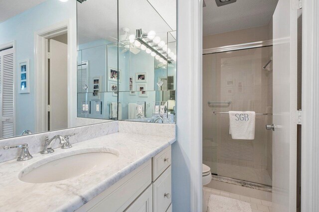 bathroom featuring vanity, toilet, and a shower with door