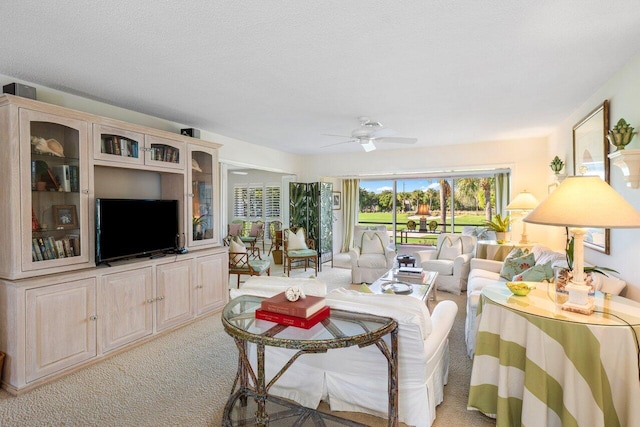 living room featuring a textured ceiling, light colored carpet, and ceiling fan