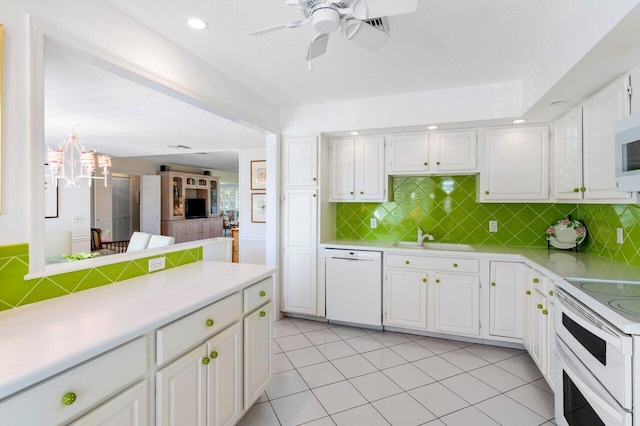 kitchen featuring sink, light tile patterned floors, white cabinets, and white appliances