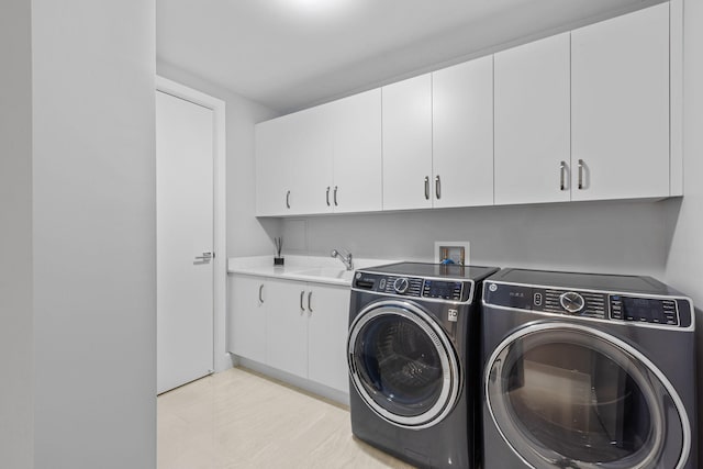 washroom with cabinets, sink, and washer and dryer