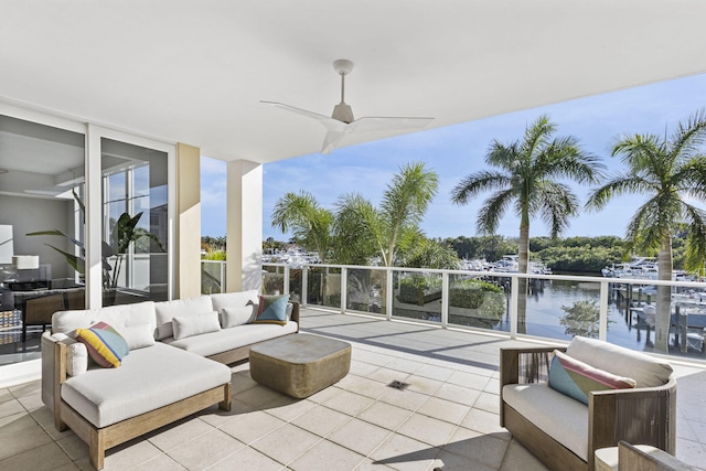 view of patio featuring a balcony, a water view, an outdoor hangout area, and ceiling fan