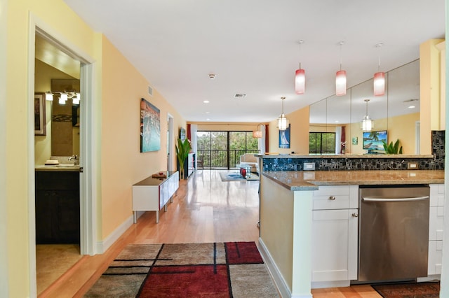 kitchen with pendant lighting, white cabinetry, light hardwood / wood-style floors, stone countertops, and stainless steel dishwasher