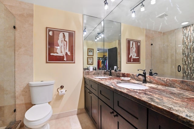 bathroom featuring tile patterned floors, vanity, toilet, and a shower with shower door