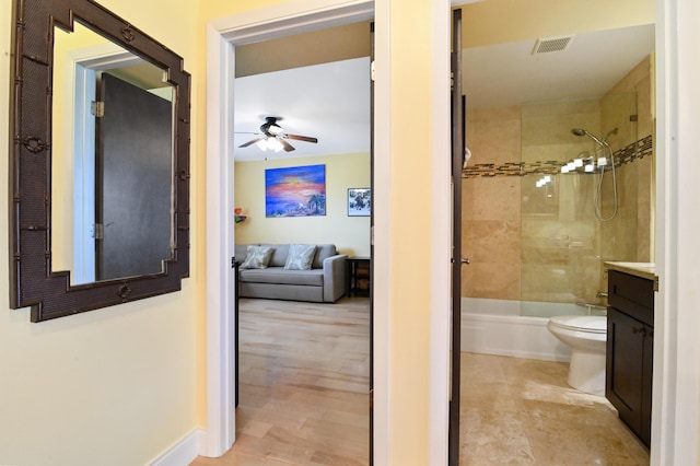 full bathroom featuring vanity, tiled shower / bath, ceiling fan, and toilet