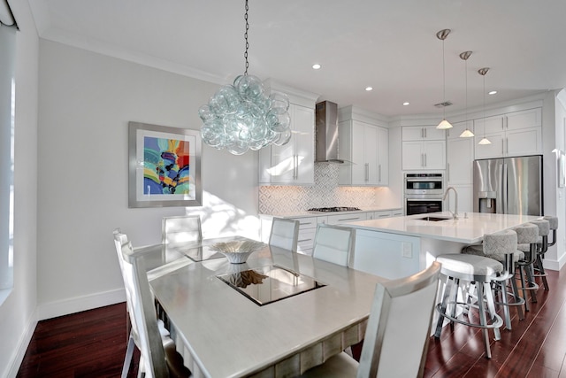 dining area with ornamental molding, dark hardwood / wood-style floors, and sink