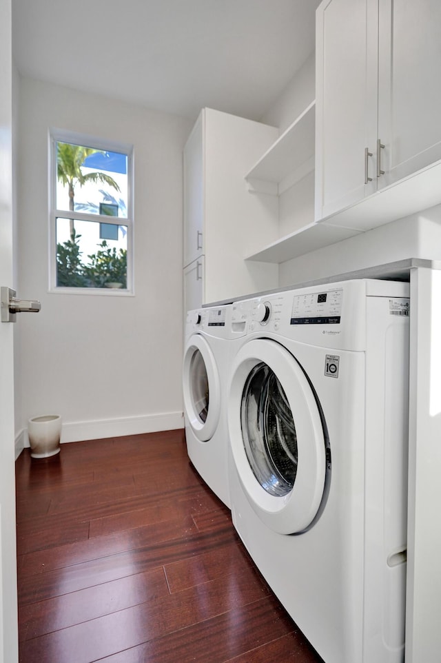 laundry room featuring cabinets, dark hardwood / wood-style floors, and washer and dryer