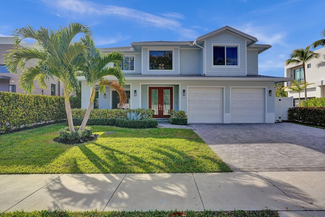 view of front of home featuring french doors, a garage, and a front lawn