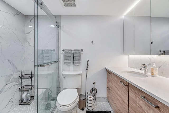 3605 S Ocean Blvd Unit 312, South Palm Beach, FL 33480 - full bathroom featuring toilet, visible vents, a marble finish shower, and vanity