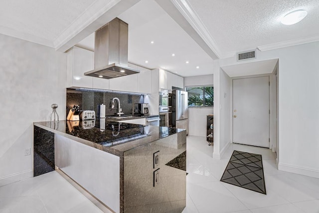 3605 S Ocean Blvd Unit 312, South Palm Beach, FL 33480 - kitchen with modern cabinets, visible vents, island exhaust hood, crown molding, and white cabinets