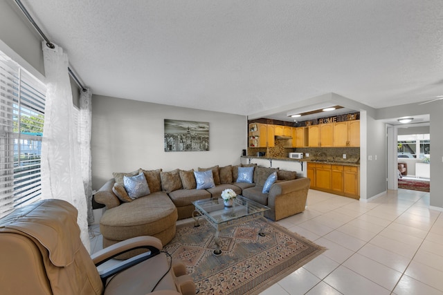 living room featuring a textured ceiling and light tile patterned flooring