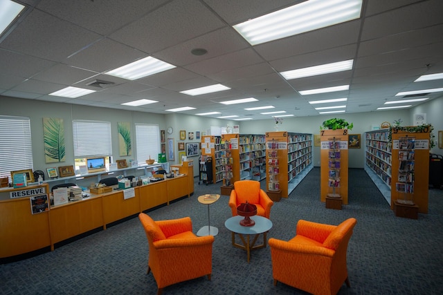 interior space with a drop ceiling and dark colored carpet