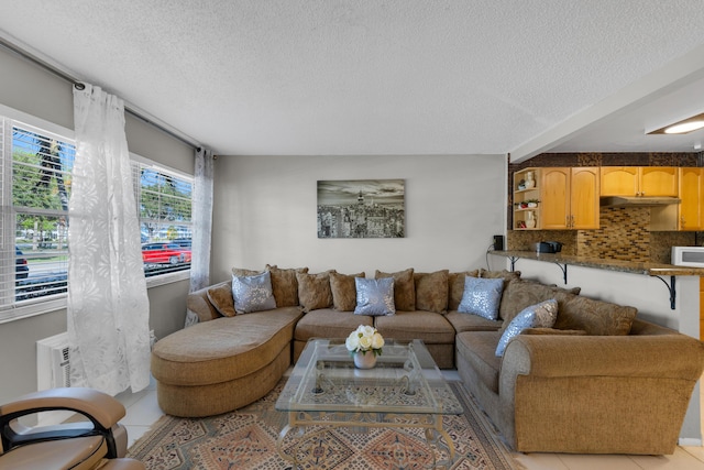 tiled living room featuring a textured ceiling