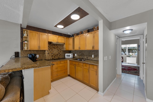 kitchen featuring kitchen peninsula, sink, decorative backsplash, and light tile patterned floors