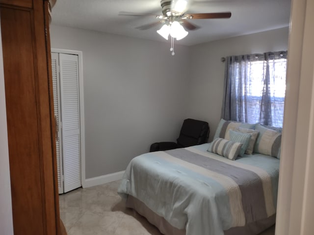 bedroom featuring ceiling fan, a closet, and light tile patterned floors