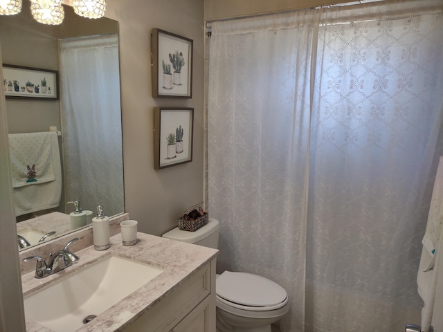 bathroom with vanity, a chandelier, and toilet