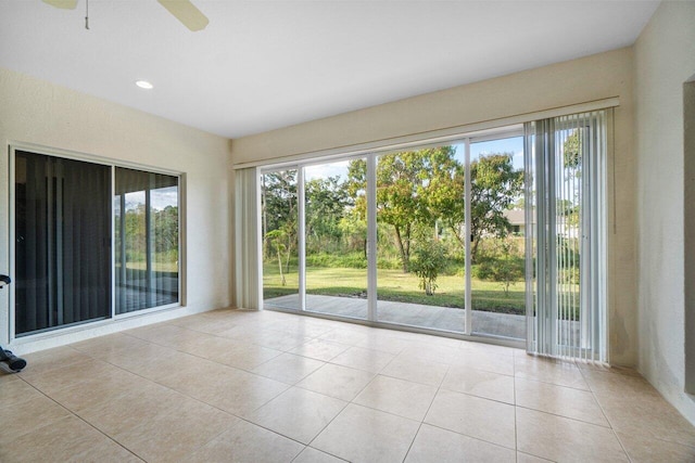 tiled empty room featuring ceiling fan