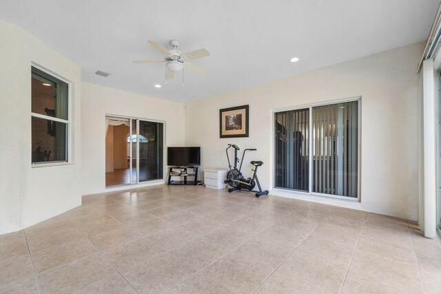 unfurnished living room featuring ceiling fan and light tile patterned flooring