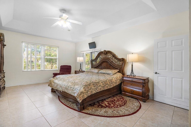 bedroom featuring light tile patterned floors, a raised ceiling, and ceiling fan