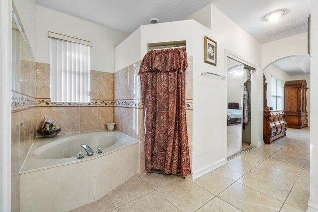 bathroom featuring plus walk in shower and tile walls