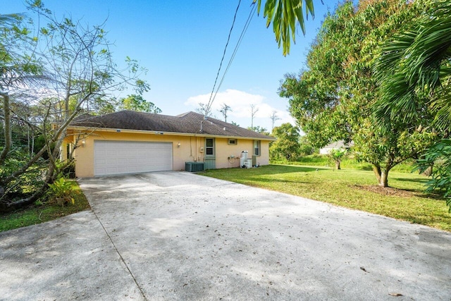 ranch-style home with a garage, central AC, and a front lawn