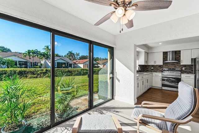 sunroom with ceiling fan and a residential view