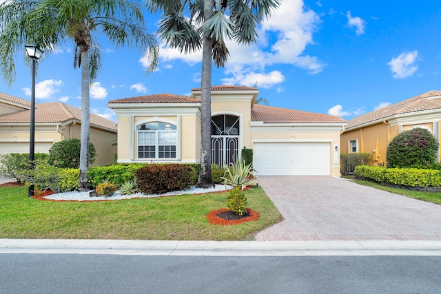 mediterranean / spanish-style home featuring a garage and a front yard