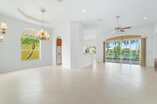 unfurnished room with light tile patterned flooring, a water view, and ceiling fan with notable chandelier